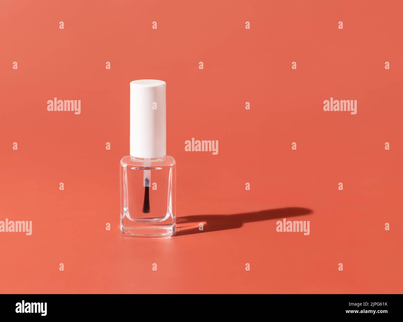 Nachfüllbare Flasche aus klarem Glas mit Bürstendeckel auf rosa, hartem Schatten, Nahaufnahme, Nachbildung. Hautpflege oder Nagelprodukt. Naturkosmetik, minimale Zusammensetzung Stockfoto