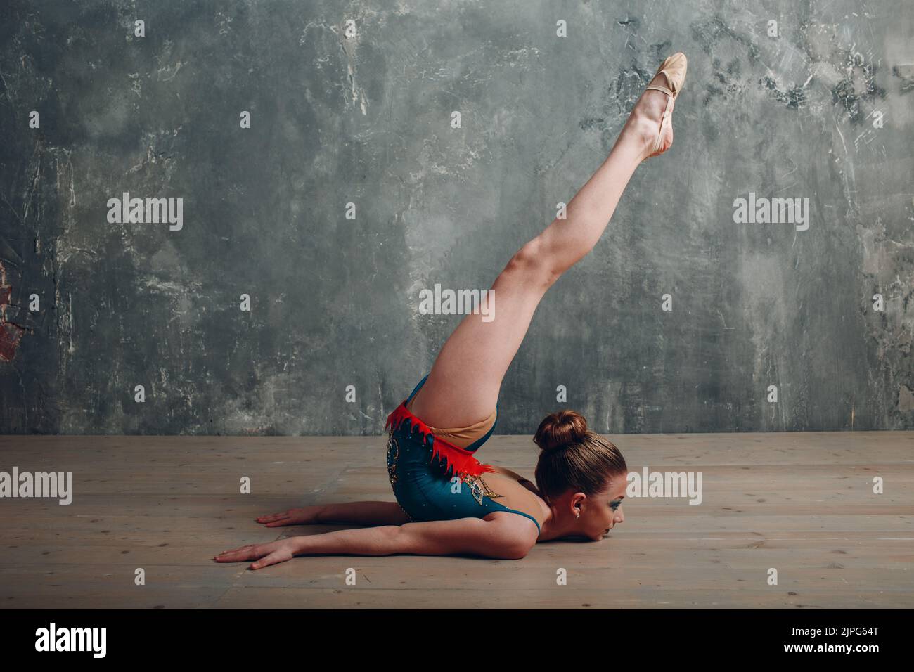 Junge Mädchen professionelle Turnerin Frau tanzen rhythmische Gymnastik mit Band im Studio. Stockfoto