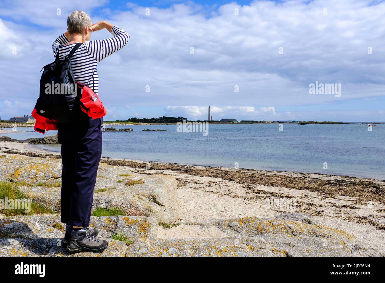 Frankreich, Gatteville-le Phare, 01.07.2022: Eine Wanderin zeigt auf den Leuchtturm von Gatteville an der Pointe de Barfleur bei Gatteville-le Phare Stockfoto