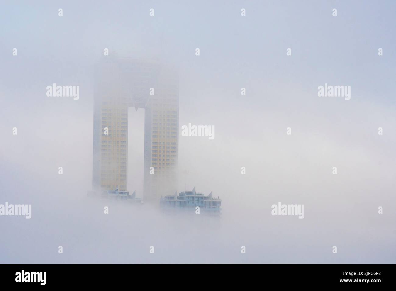 Die Spitze des Intempo-Wolkenkratzers erhebt sich über dem Nebel in Benidorm, Spanien Stockfoto