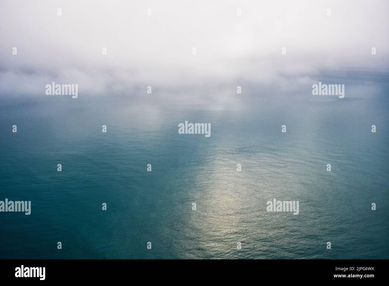 Die Sonne bricht durch Nebel über dem Mittelmeer vor Benidorm, Spanien Stockfoto