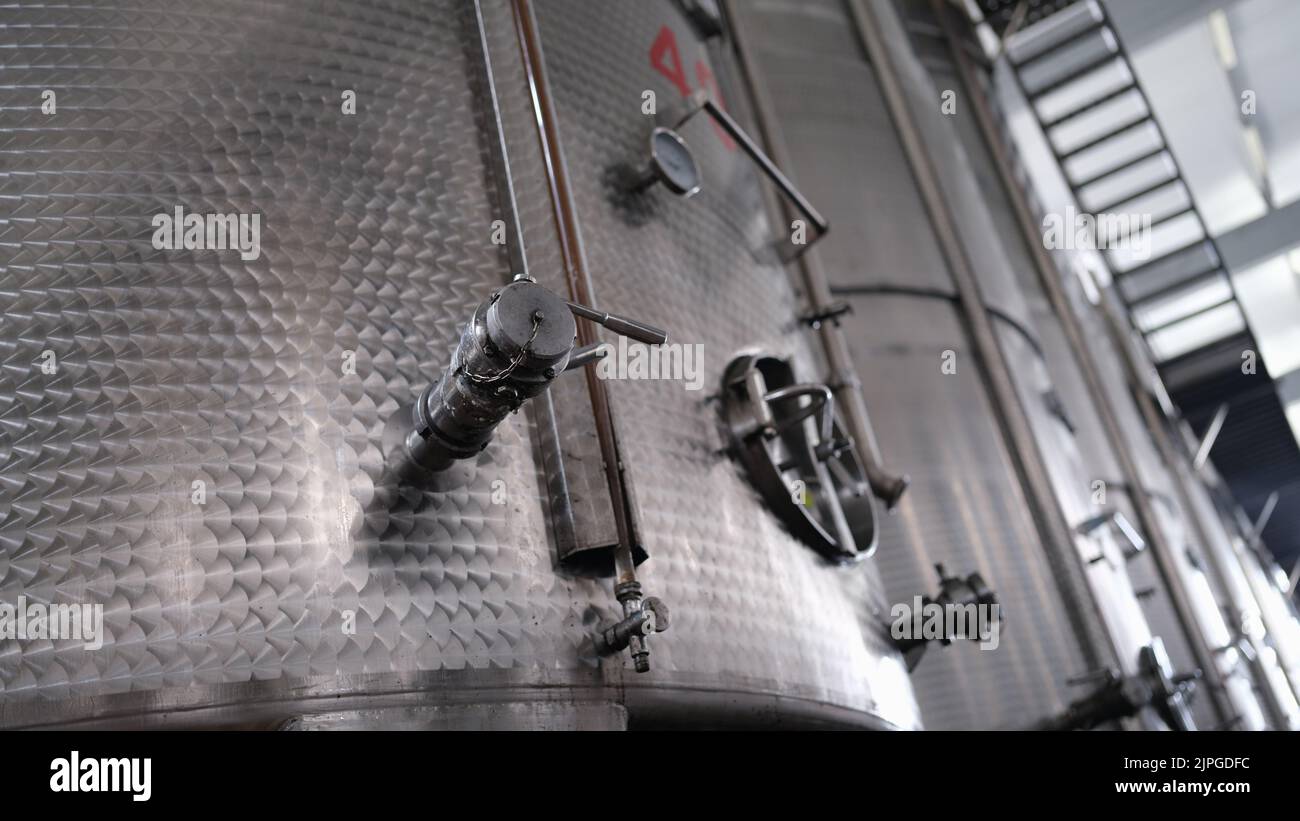 Moderne Weinbrennerei und Brauerei mit Brühkesselrohren und Edelstahltanks Stockfoto