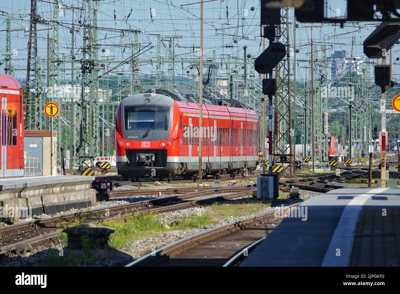 Das Bild zeigt einen roten Zug, der in den Augsburger Hauptbahnhof in Bayern einfährt Stockfoto