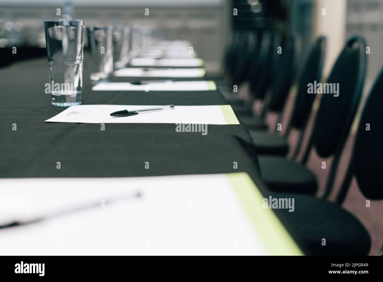 Eine leere Reihe moderner Stühle am Tisch in einem Konferenzraum des Hotels Stockfoto