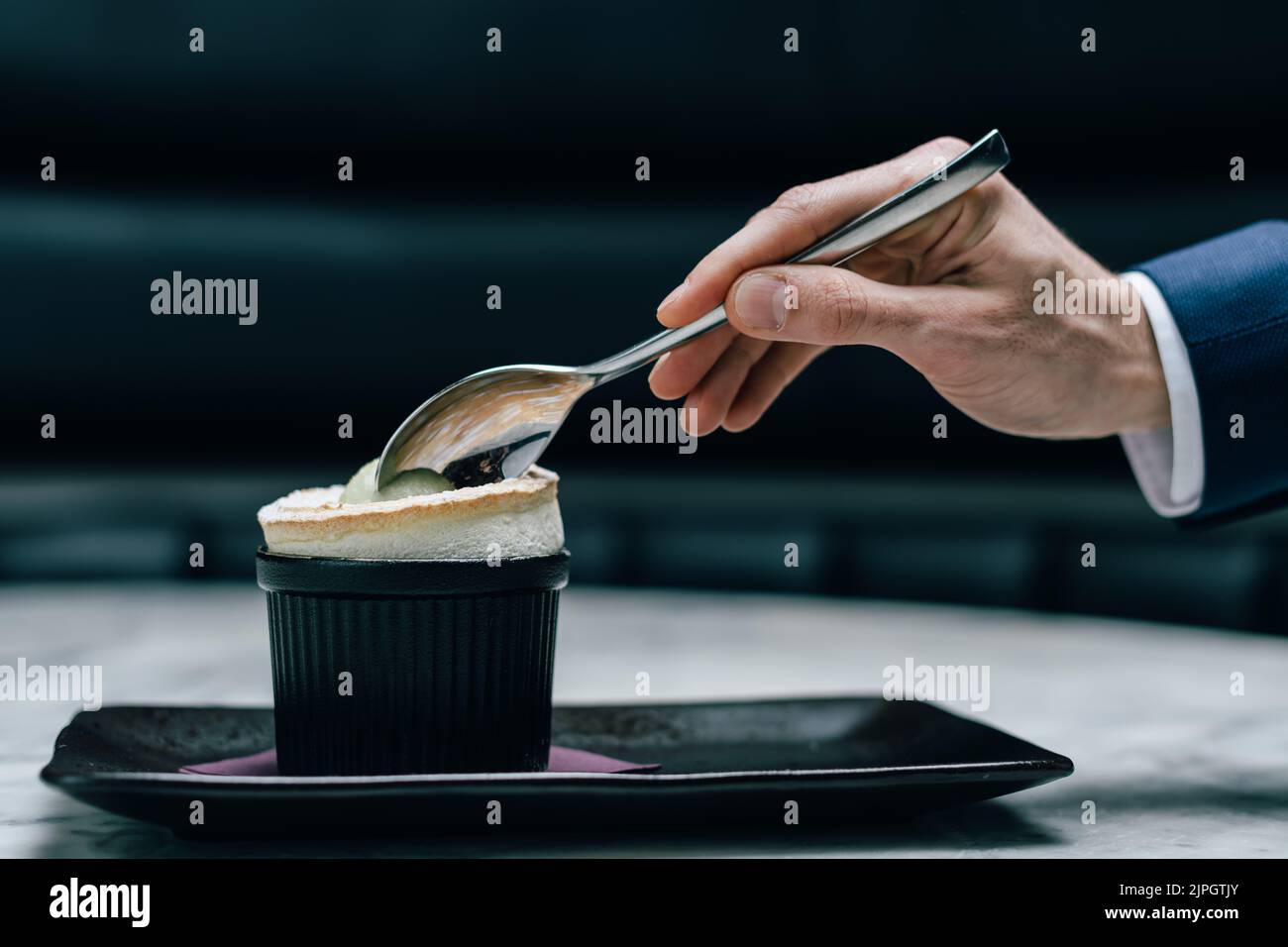 Löffel Tauchen in ein süßes Soufflé Dessert mit Sorbet an der Seite Stockfoto