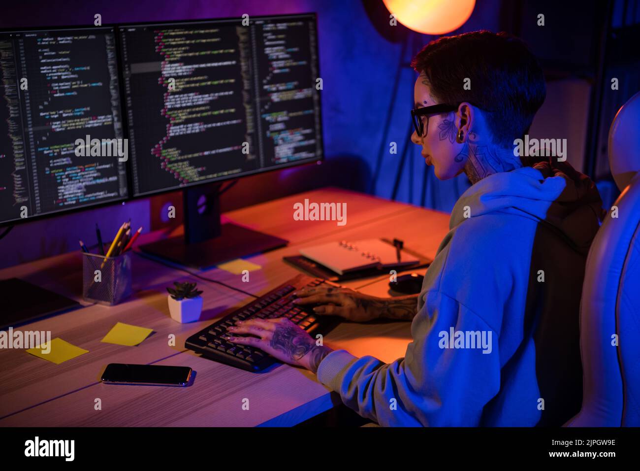 Profil Porträt von erfahrenen intelligenten Programmierer Mädchen sitzend Stuhl Tastatur Eingabe Code Arbeitsplatz drinnen Stockfoto