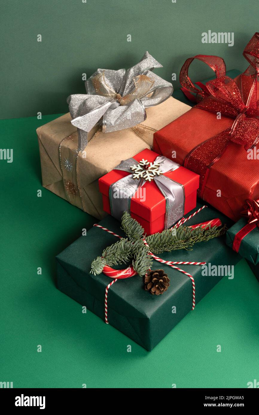 Weihnachtliche Naturdekorationen aus Holz, rote Kugeln, Geschenkbox und Notizblock auf grünem Hintergrund. Weihnachtsgruß-Design. Vorderansicht .das Konzept von Urlaub und Neujahr. Stockfoto