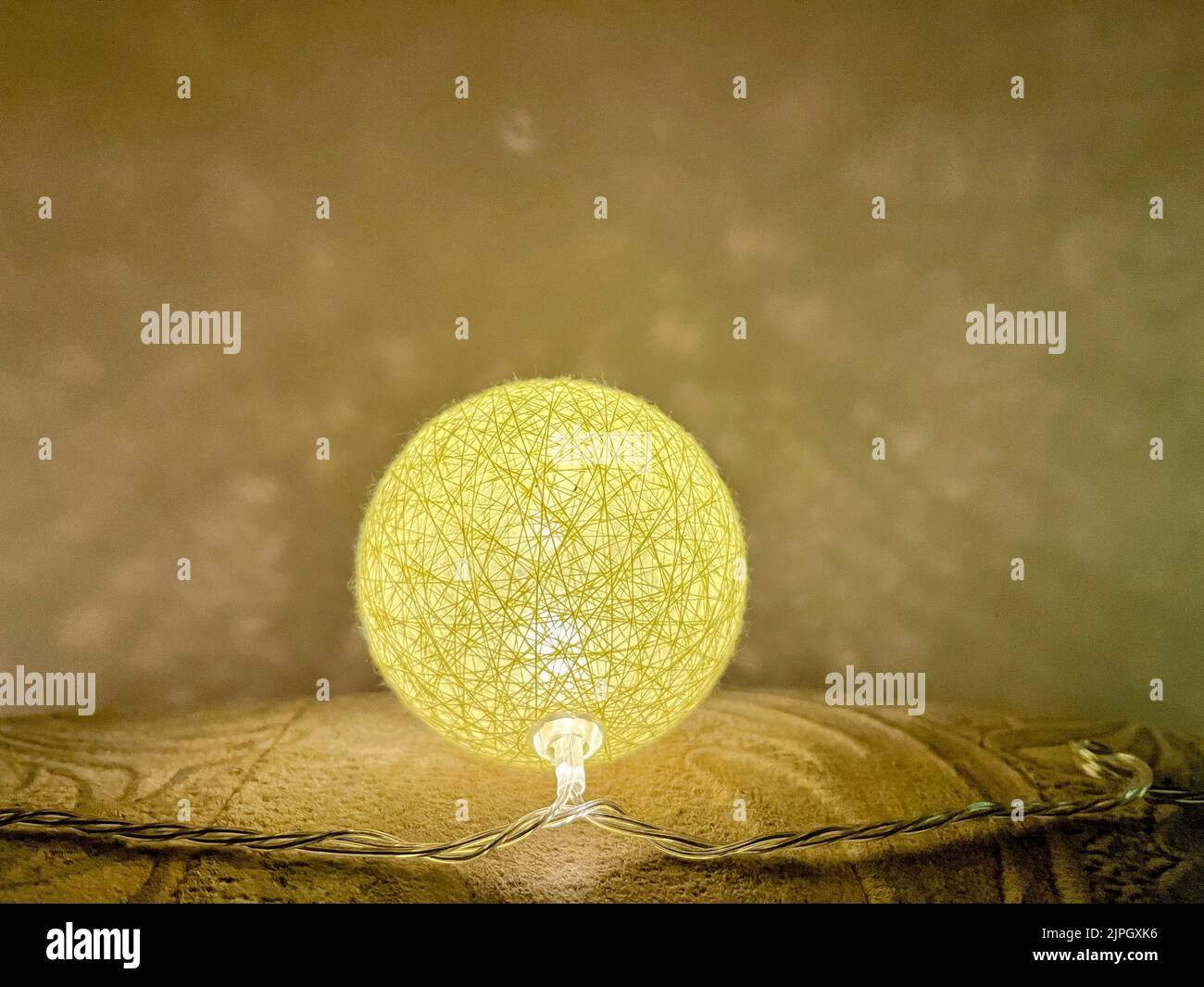 Eine Nahaufnahme einer leuchtend gelben Kugellampe. Stockfoto