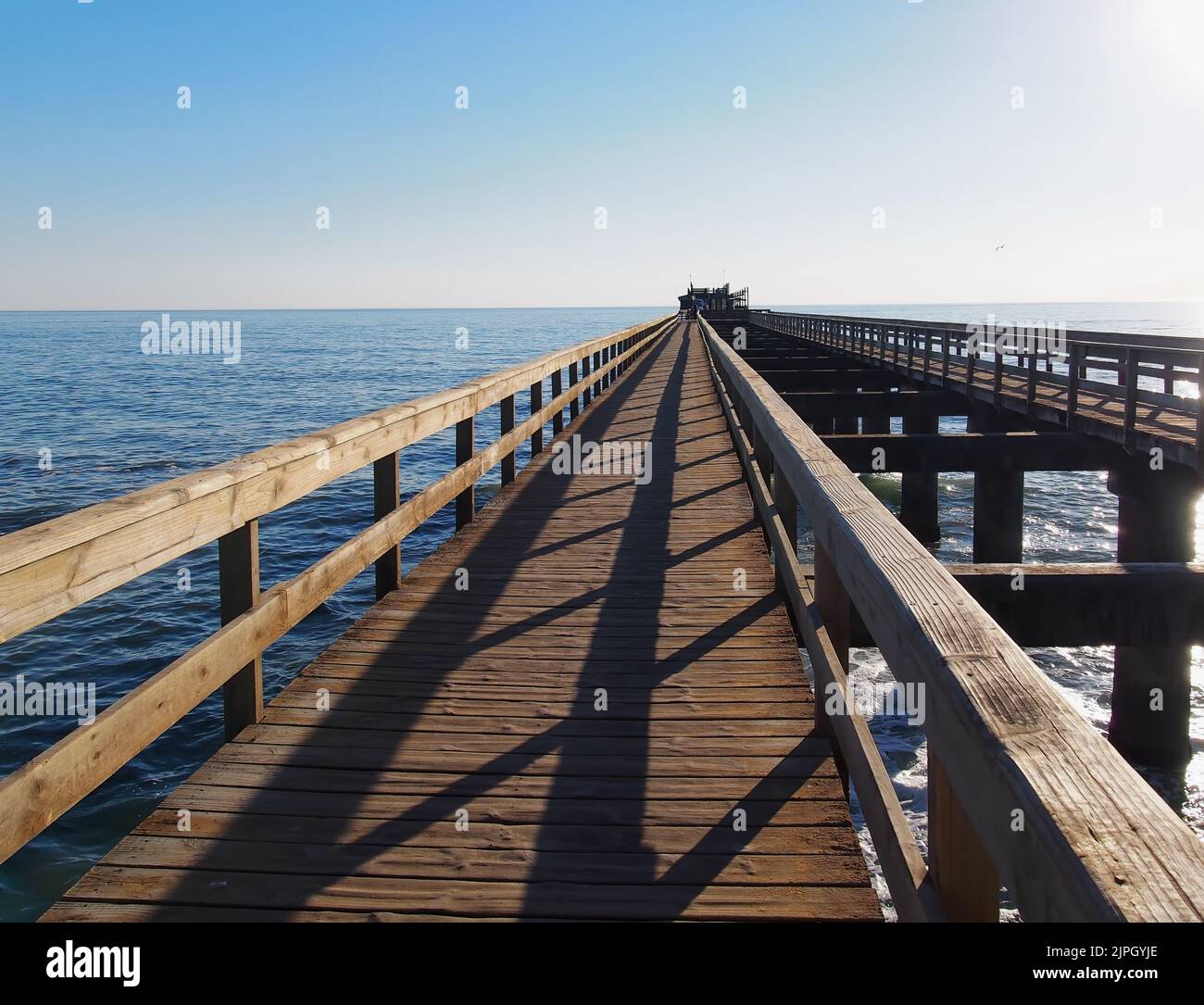 Eine Luftaufnahme einer Holzbrücke über dem Meer an sonnigen Tagen am Skeleton Beach in Namibia Stockfoto