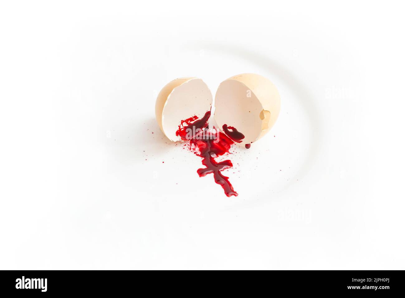 Eierschale mit Blutspur, die ein Kruzifix bildet. Abtreibung metaphorisches Konzept. Stockfoto