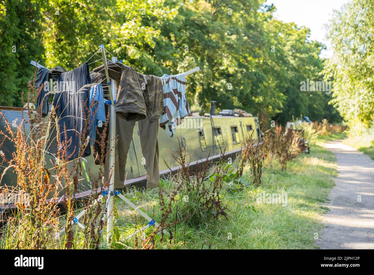 Das britische Kanalboot liegt am Worcestershire Towpath, wo an heißen Sommertagen Kleidung an einer tragbaren Drehspüllinie getrocknet wird. Stockfoto