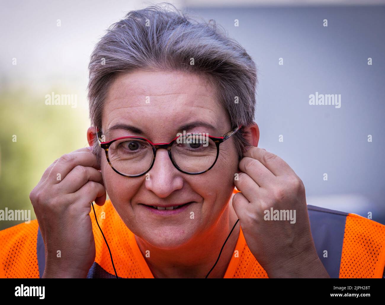 Wismar, Deutschland. 18. August 2022. Klara Geywitz (SPD), Bundesministerin für Wohnungsbau, Stadtentwicklung und Bauwesen, legt bei einem Besuch im Holzwerk Egger Gehörschutz in die Ohren. Bei ihrem eintägigen Besuch in Mecklenburg-Vorpommern informiert sich die Ministerin über nachhaltiges Bauen und neue Baustoffe und besucht neben dem Holzwerk auch die Fachagentur für nachwachsende Rohstoffe und eine Wohngenossenschaft. Quelle: Jens Büttner/dpa/Alamy Live News Stockfoto