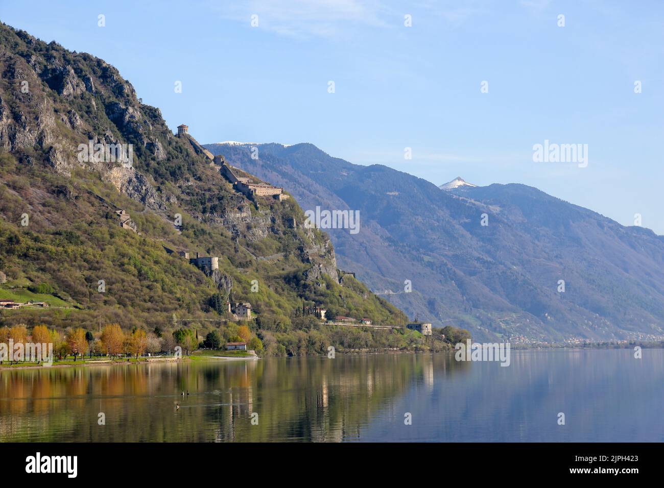 Idrosee, Italien - 18. April 2018: Blick auf das Westufer des Idrosees in Norditalien, in der Ferne ein schneebedeckter Berggipfel. Hoch über Th Stockfoto