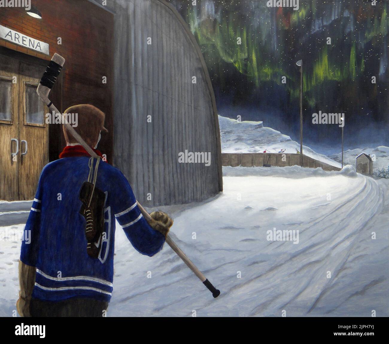 Ein Hockeyspieler geht an einem Arengebäude vorbei, um an einer kalten Winternacht in der kanadischen Landschaft zu einer entfernten Außenbahn zu gelangen. Stockfoto