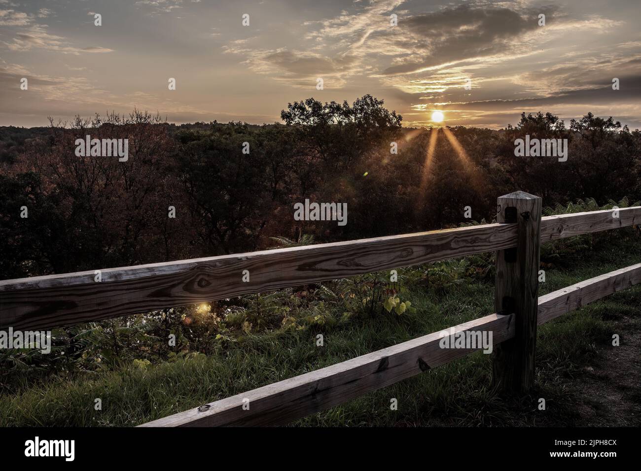 Sonnenstrahlen beim Sonnenaufgang vom Heritage Park in Taylors Falls, Minnesota, USA, im Herbst über dem Horizont. Stockfoto