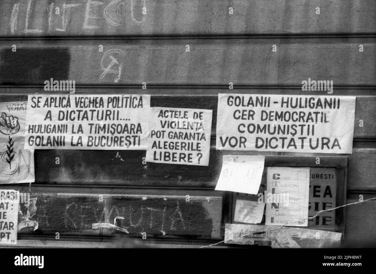 Bukarest, Rumänien, April 1990. „Golaniada“, ein großer Anti-Kommunismus-Protest auf dem Universitätsplatz nach der rumänischen Revolution von 1989. Die Menschen versammelten sich täglich, um gegen die Ex-Kommunisten zu protestieren, die nach der Revolution die Macht ergriffen hatten. Am Universitätsgebäude hingen verschiedene Plakate. Stockfoto