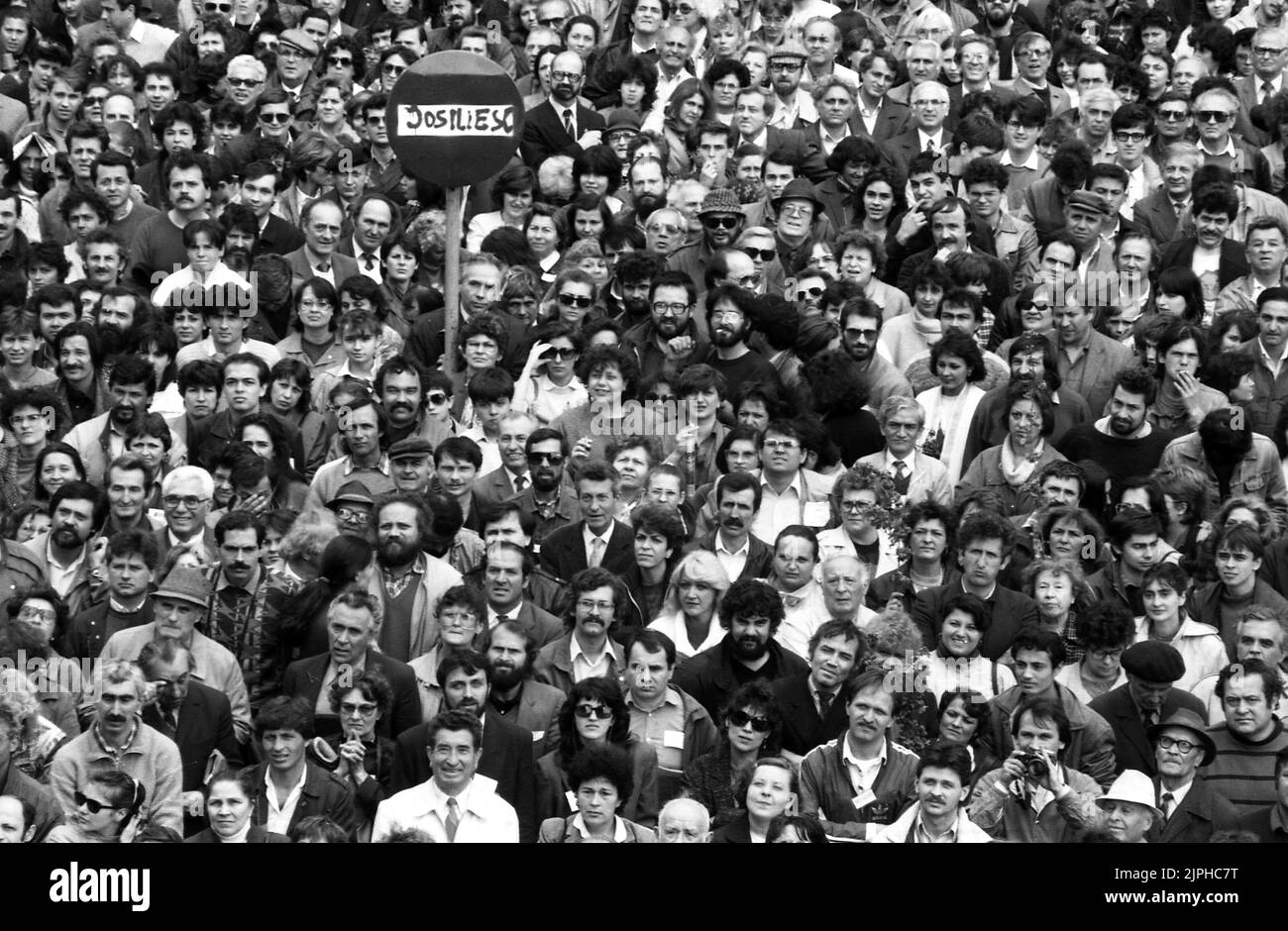 Bukarest, Rumänien, April 1990. „Golaniada“, ein großer Anti-Kommunismus-Protest auf dem Universitätsplatz nach der rumänischen Revolution von 1989. Die Menschen versammelten sich täglich, um gegen die Ex-Kommunisten zu protestieren, die nach der Revolution die Macht ergriffen hatten. Die Hauptforderung war, dass kein ehemaliges Parteimitglied bei den Wahlen im Mai 20. kandidieren darf. Auf dem Schild steht 'Jos Iliescu' (Down with Iliescu). Iliescu, ein ehemaliger kommunistischer Beamter, wurde nach der Revolution provisorischer Präsident und wurde schließlich bei den umkämpften Wahlen im Mai 1990 zum Präsidenten gewählt. Stockfoto