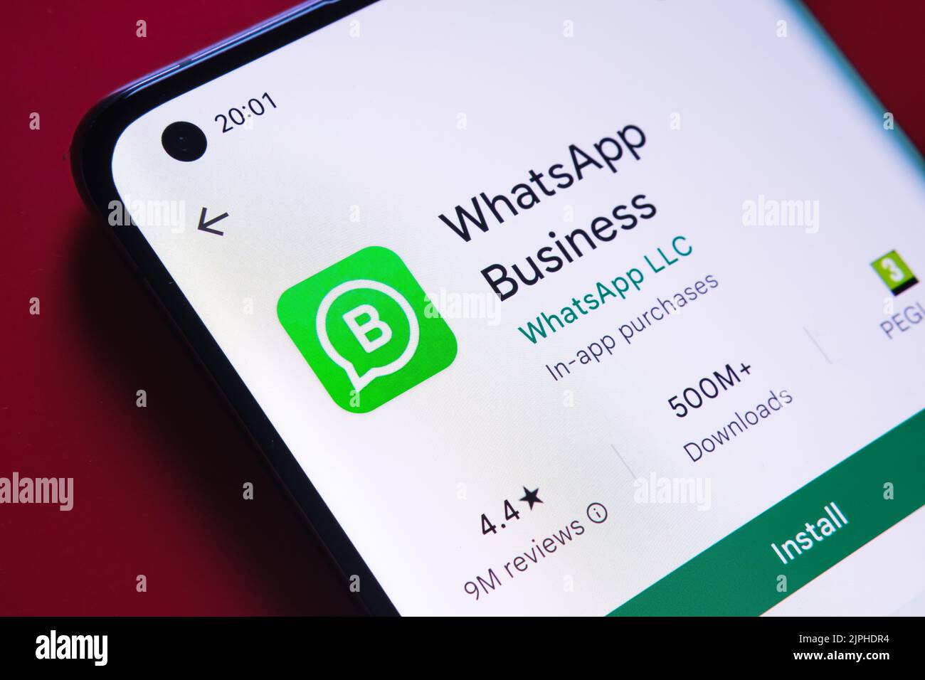 whatsapp Business App im Google Play Store auf dem Smartphone-Bildschirm auf rotem Hintergrund gesehen. Nahaufnahme mit selektivem Fokus. Stafford, Einheit Stockfoto