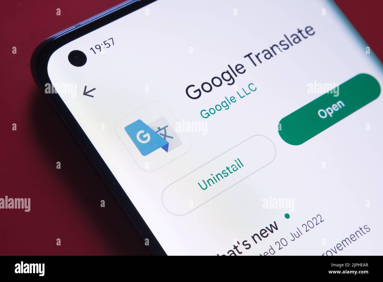 google Translate App in Google Play Store auf dem Smartphone-Bildschirm auf rotem Hintergrund platziert gesehen. Nahaufnahme mit selektivem Fokus. Stafford, Vereinigt Euch Stockfoto