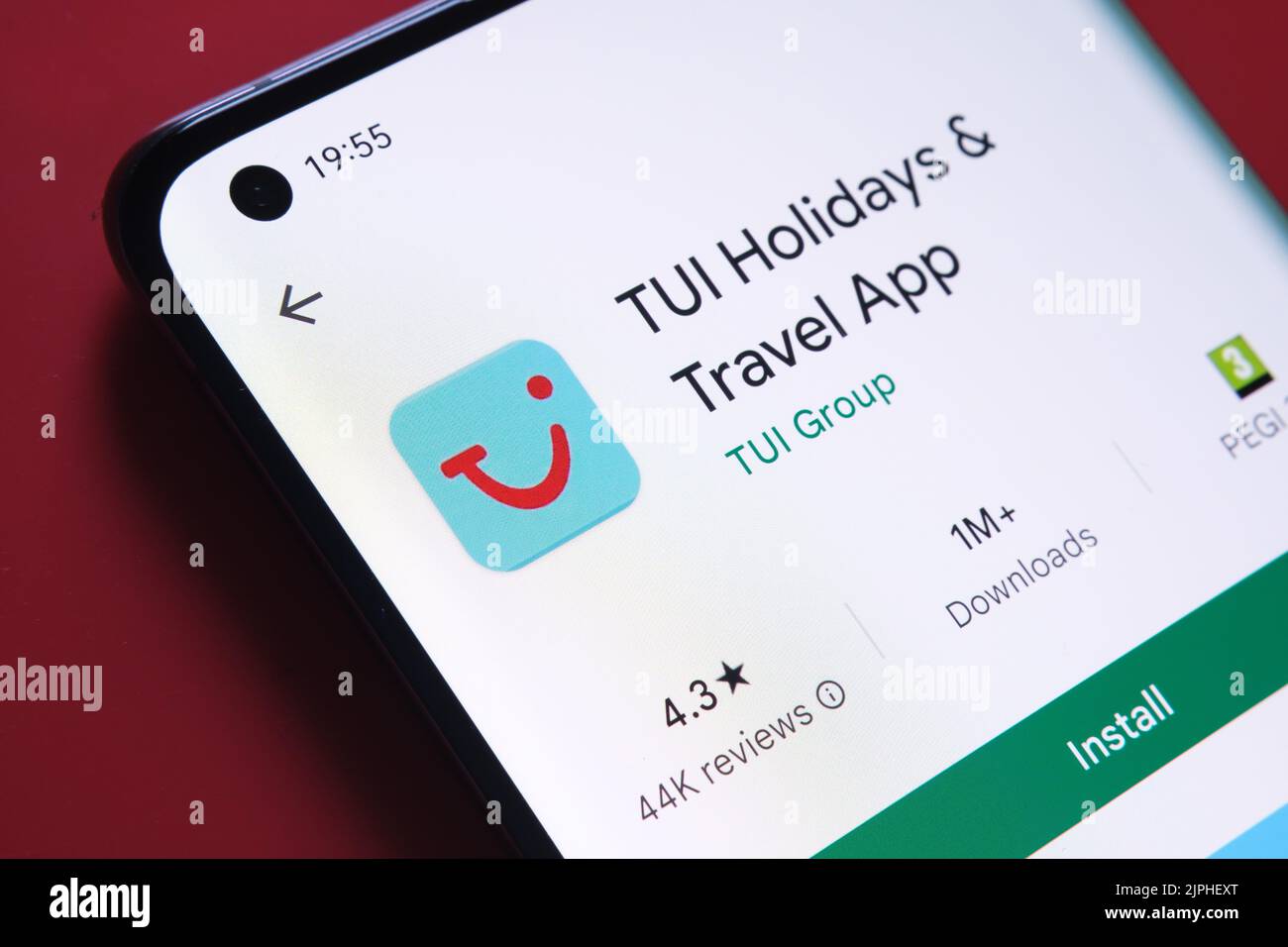 TUI Holidays App im Google Play Store auf dem Smartphone-Bildschirm auf rotem Hintergrund angezeigt. Nahaufnahme mit selektivem Fokus. Stafford, Vereinigte Ki Stockfoto