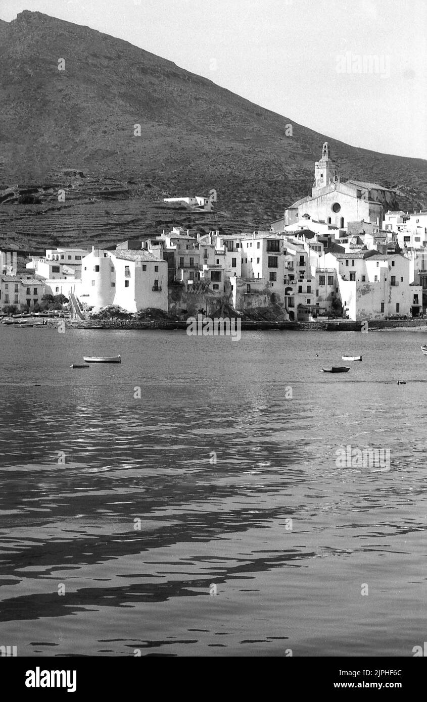 1960s, historische Ansicht aus dieser Zeit der Küstenstadt Cadaqués, Girona, Spanien. Hübsche Dorfhäuser rund um eine Bucht auf der Halbinsel Cape de Creus an der Costa Brava des Mittelmeers. Der spanische Surrealist Salvador Dalí besuchte Cadaqués in seiner Kindheit und hatte später ein Zuhause in Port Lligat, einem kleinen Dorf an einer Bucht neben der Stadt. Stockfoto