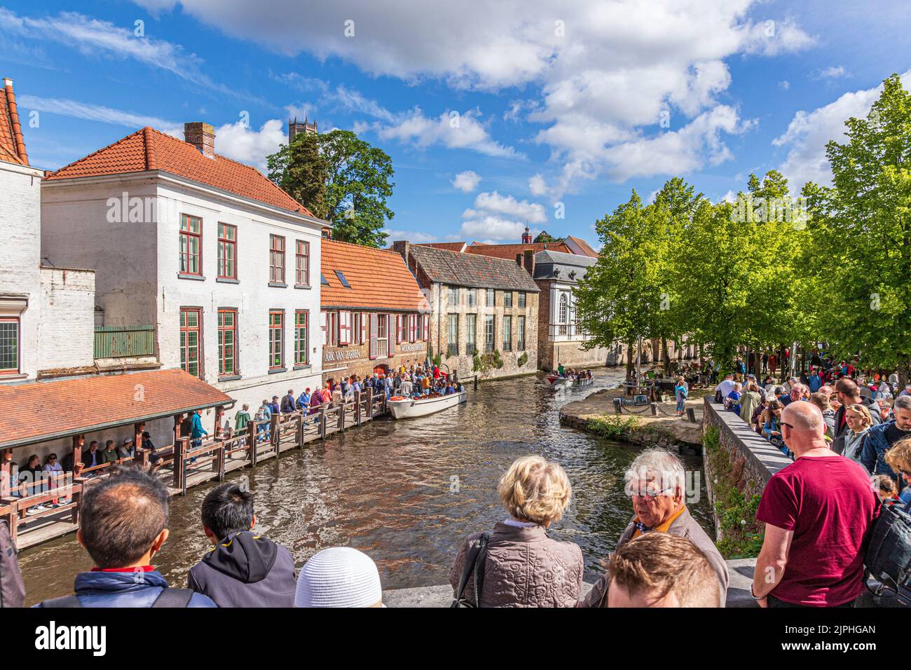 Touristen, die sich für eine geführte Bootstour um die Kanäle von Brügge, Belgien, anstellen Stockfoto