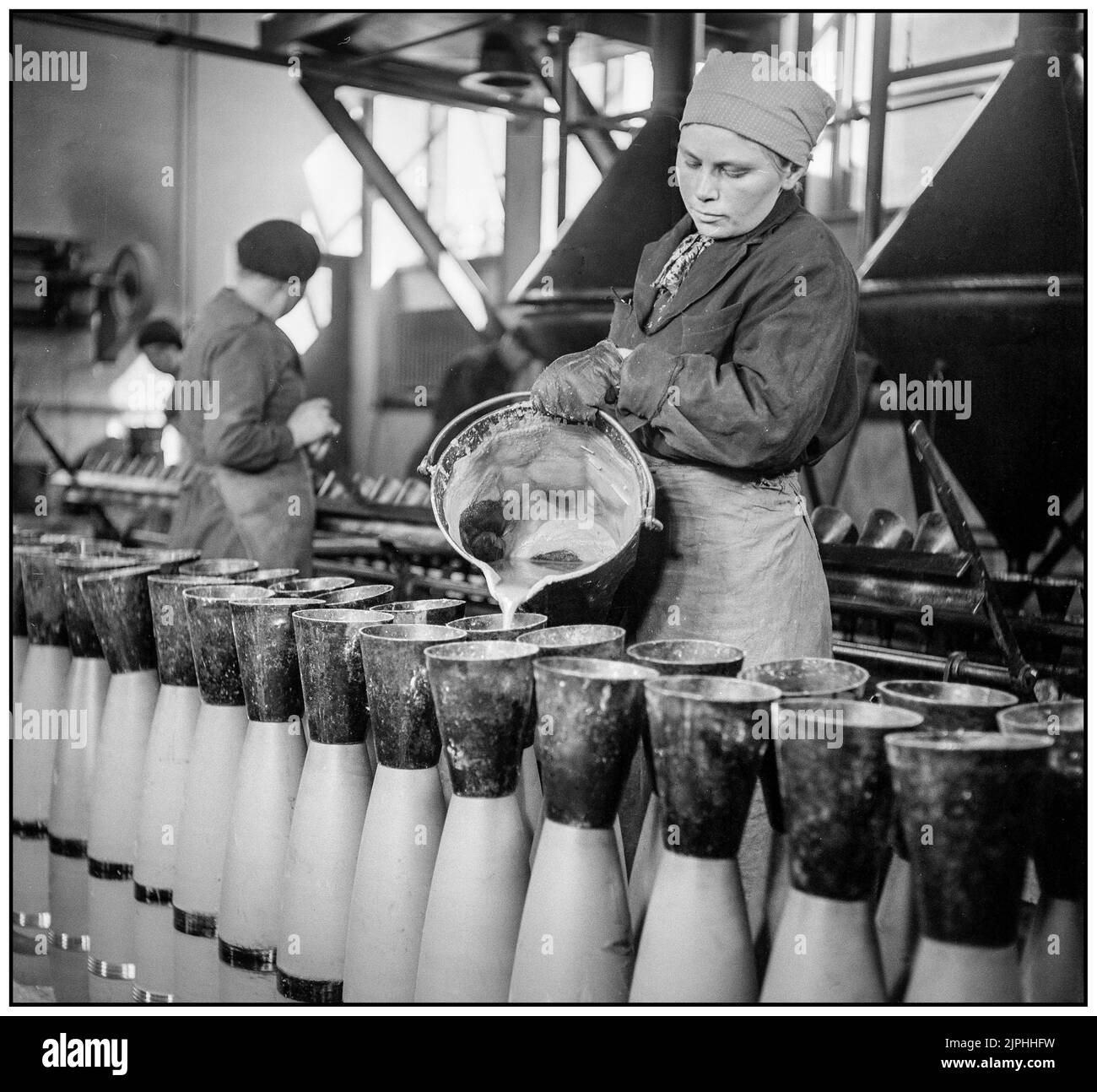 FINNLAND MILITÄRISCHE PRODUKTION 152mm Shell-Produktion in Finnland 1942s Zweiten Weltkrieg Gießen von flüssigen Amatol Amatol ist ein hochexplosives Material, das aus einer Mischung aus TNT und Ammoniumnitrat hergestellt wird.der britische Name stammt von den Wörtern Ammonium und Toluol (der Vorstufe von TNT). Ähnliche Mischungen (ein Teil Dinitronaphthalin und sieben Teile Ammoniumnitrat) wurden in Frankreich als Schneiderit bezeichnet. Amatol wurde während des Ersten und Zweiten Weltkriegs ausgiebig eingesetzt, typischerweise als Sprengstoff in militärischen Waffen wie Flugzeugbomben, Granaten, Tiefenladungen und Marineminen. Stockfoto