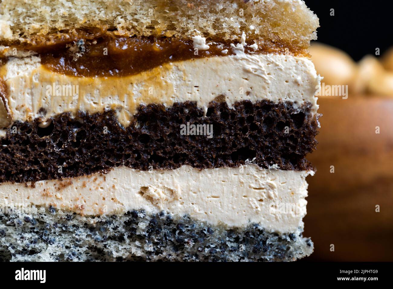 Mehrschichtiger Kuchen mit verschiedenen Schichten, Karamell, Mohn und Cremeschichten Kuchen zum Dessert mit Nüssen Stockfoto