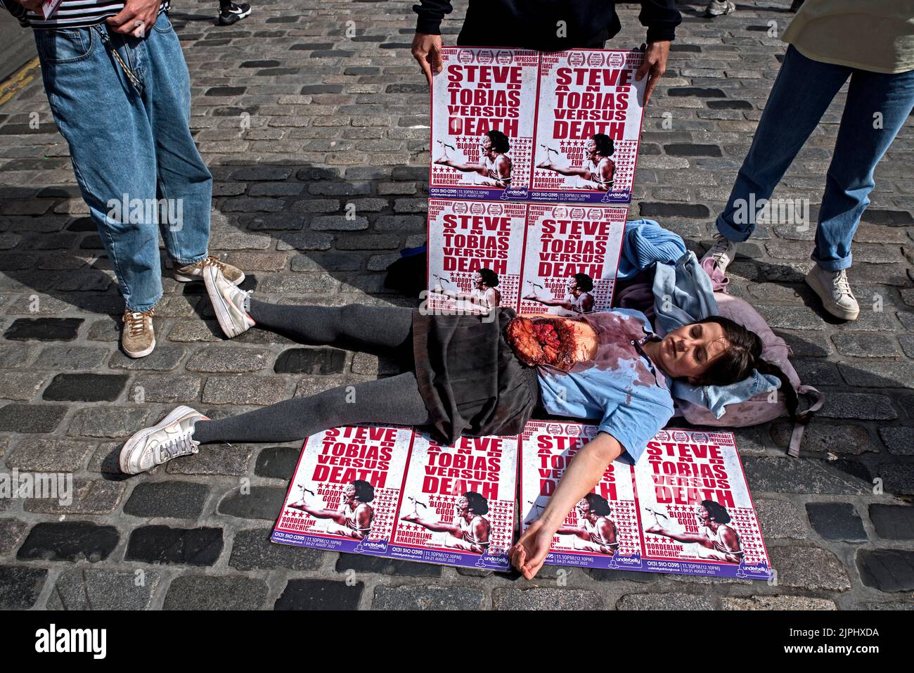 Mitglied des Paper Mug Theatre, das „Steve and Tobias versus Death“ beim Edinburgh Fringe Festival auf der Royal Mile, Edinburgh, Schottland, Großbritannien, promote. Stockfoto