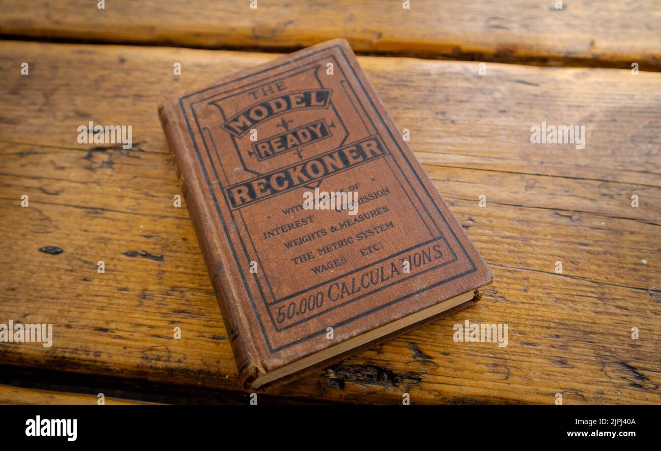 Eine Nahaufnahme eines alten Buches über Gewichte und Maße isoliert auf dem Eichentisch Stockfoto