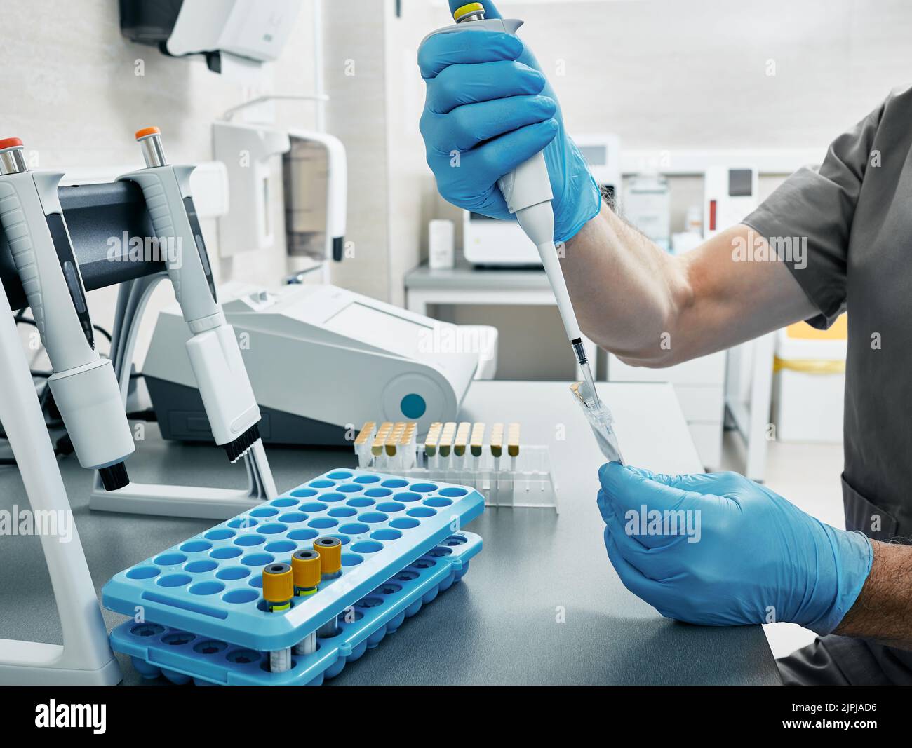 Wissenschaftler in Handschuhen und mit Mikropipette in den Händen im medizinischen Labor. Laborant bestimmt Blutgruppe und Rh-Faktor durch Gel-Agglut Stockfoto