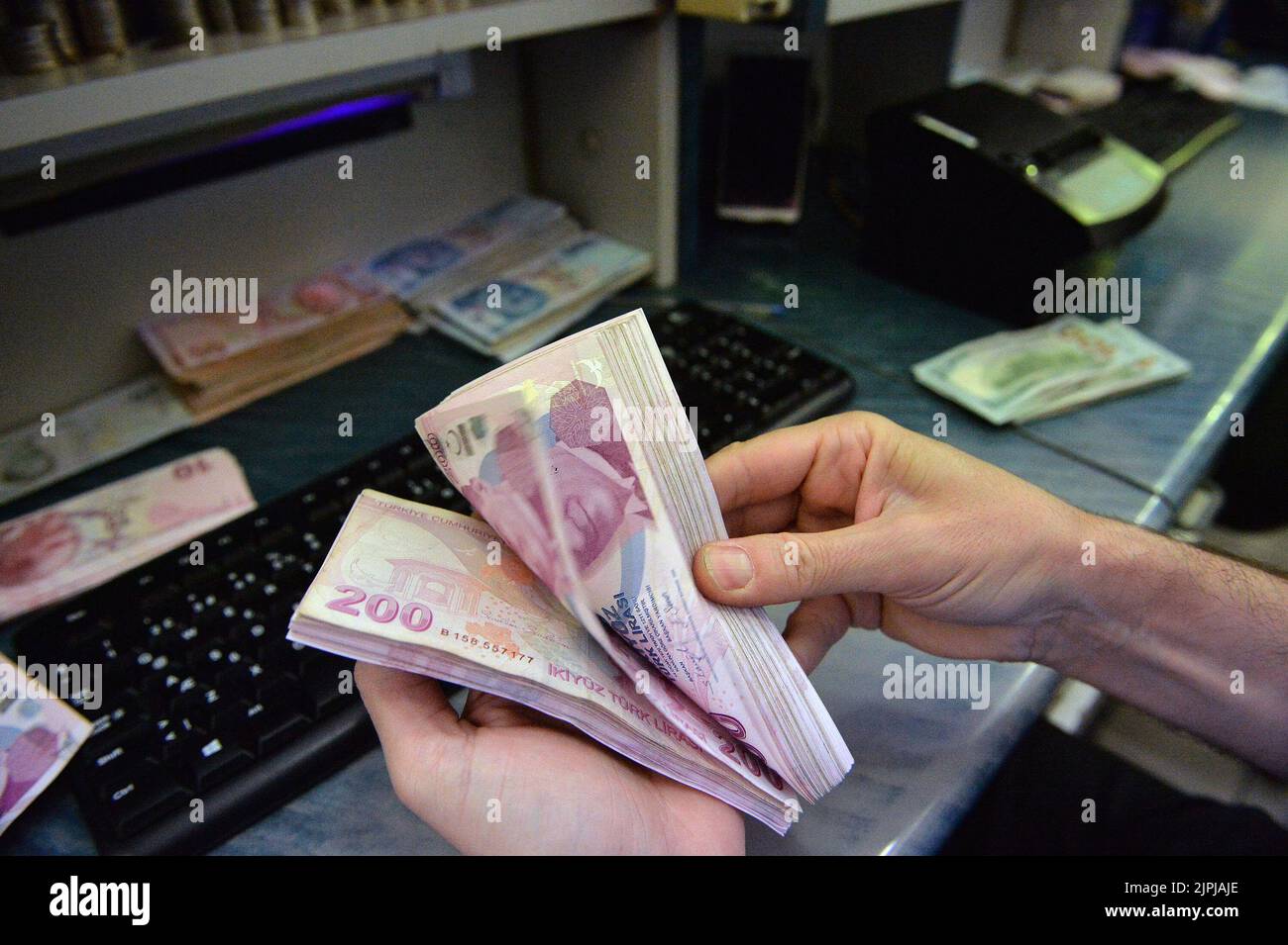 Ankara, T¨¹rkiye. 18. August 2022. Ein Erzähler zählt am 18. August 2022 türkische Lira in einem Devisenbüro in Ankara, T¨¹rkiye. Die türkische Zentralbank hat am Donnerstag eine überraschende Zinssenkung von 14 Prozent auf 13 Prozent vorgenommen und damit ihre Währung auf den niedrigsten Punkt in diesem Jahr gesenkt. Quelle: Mustafa Kaya/Xinhua/Alamy Live News Stockfoto