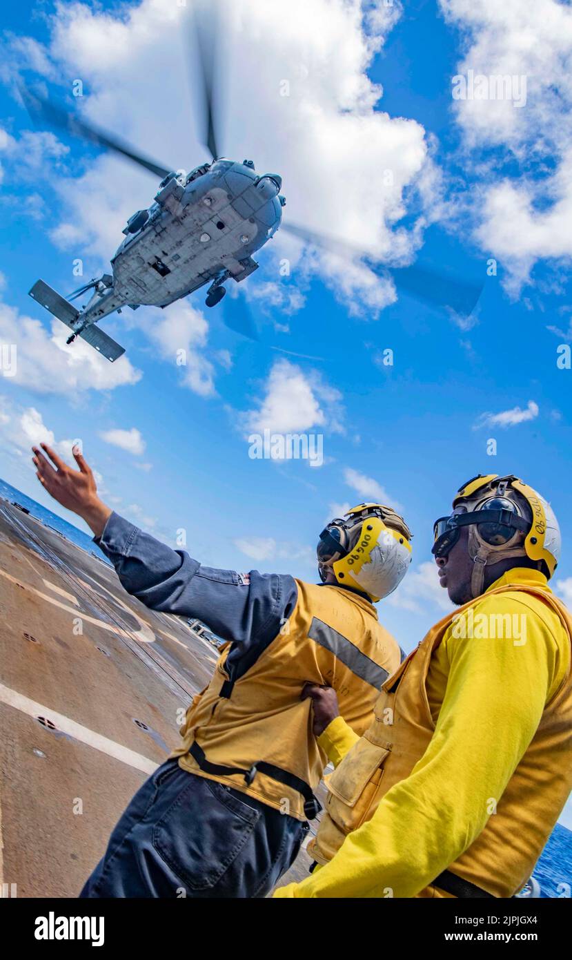 PACIFIC OCEAN (27. Juli 2022) Boatswains Mate 3. Class Jaden Journet unterstützt die Mate 3. Class Victor Venegas von Aviation Boatswains, als er einen MH-60s Sea Hawk leitet, der den 'Eightballern' des Helicopter Sea Combat Squadron (HSC) 8 auf dem Flugdeck des Arleigh Burke-Klasse Lenkraketenjäger USS Chafee zugewiesen wurde (DDG 90) während des Rim of the Pacific (RIMPAC) 2022. 26 Nationen, 38 Schiffe, vier U-Boote, mehr als 170 Flugzeuge und 25.000 Mitarbeiter nehmen vom 29. Juni bis zum 4. August an RIMPAC in und um die Hawaii-Inseln und Südkalifornien Teil. Der größte Internat der Welt Stockfoto