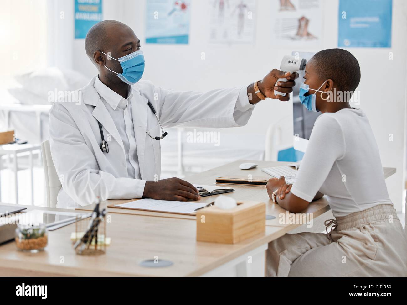Arzt überprüft die Temperatur des kovidierten Patienten, während er auf Symptome von Krankheit, Grippe oder Krankheit mit hohem Fieber testet. Screening einer Frau für eine Gesundheitskonsultiung Stockfoto