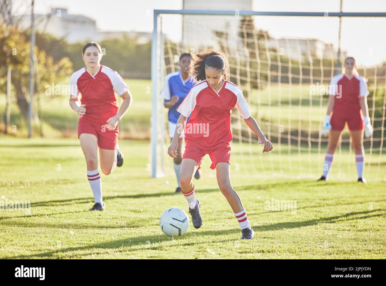 Fußball-, Sport- und Mädchenmannschaften spielen auf dem Spielfeld, während sie treten, anpacken und mit einem Ball laufen. Energie, schnelle und qualifizierte Fußballspieler Stockfoto