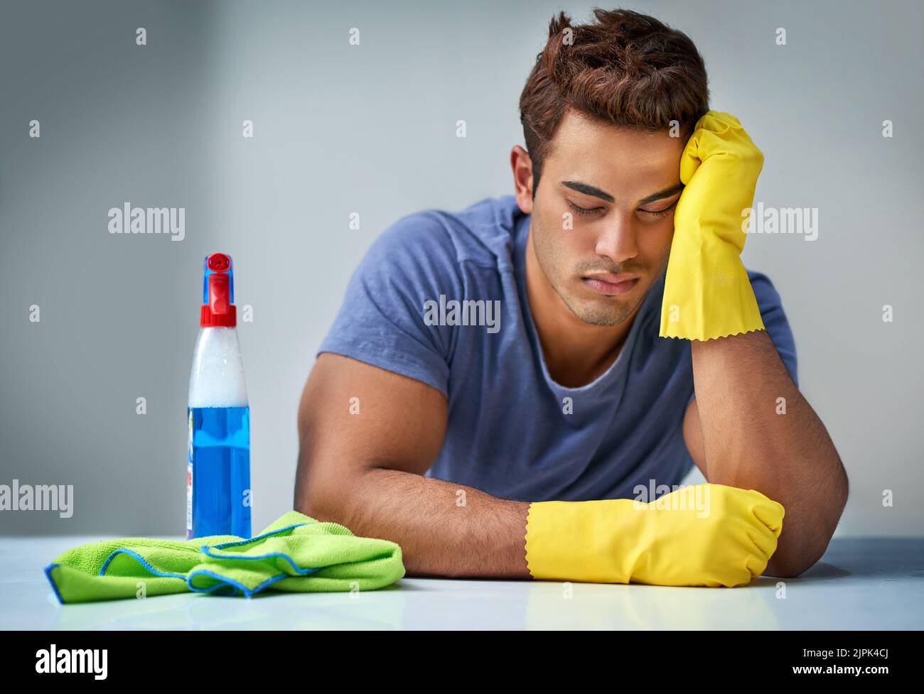 HES endlich fertig, aber erschöpft. Ein junger Mann macht Hausarbeiten. Stockfoto