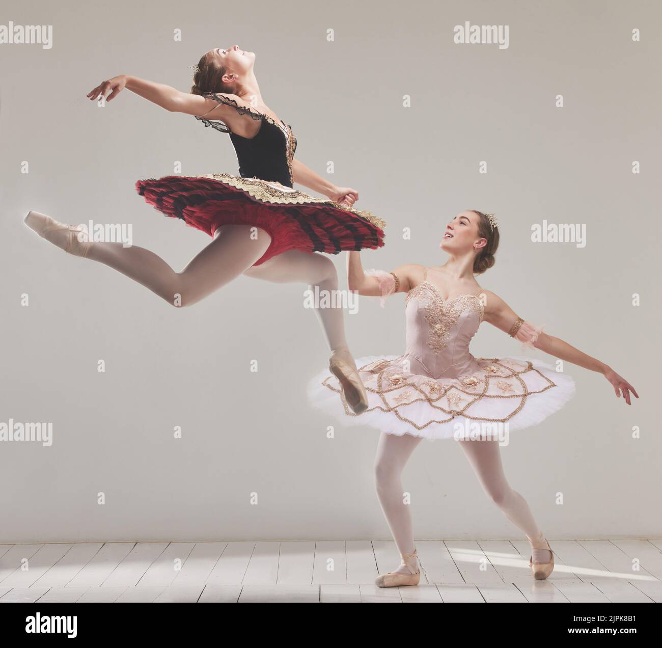 Ballerina, Balletttänzer und Performance-Künstler springen in der Luft mit Flexibilität, Bewegung und Balance in einem Studio. Energie, energetisch und klassisch Stockfoto