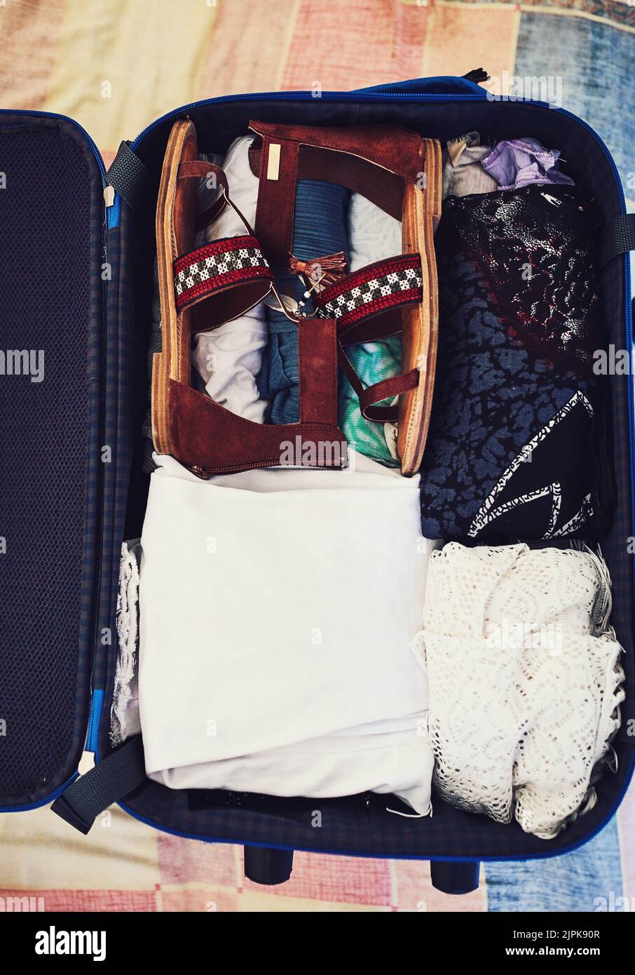 Alles für diesen Urlaub gepackt. Aufnahme eines Koffers, der mit Kleidung verpackt ist. Stockfoto