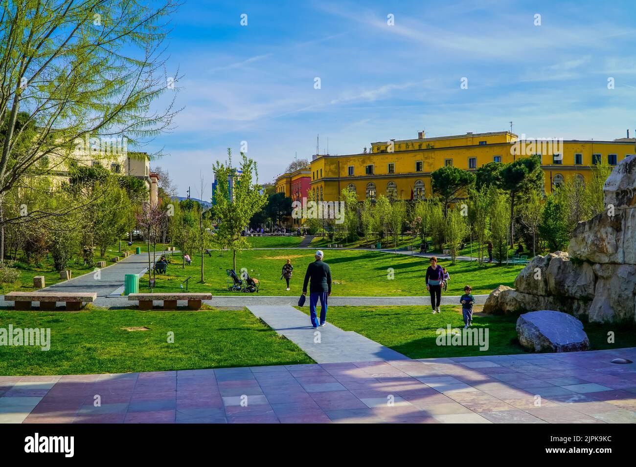 Eine wunderschöne Aussicht auf Menschen, die in einem immergrünen Park neben dem Skanderbeg-Platz in Tirana, Albanien, spazieren gehen Stockfoto