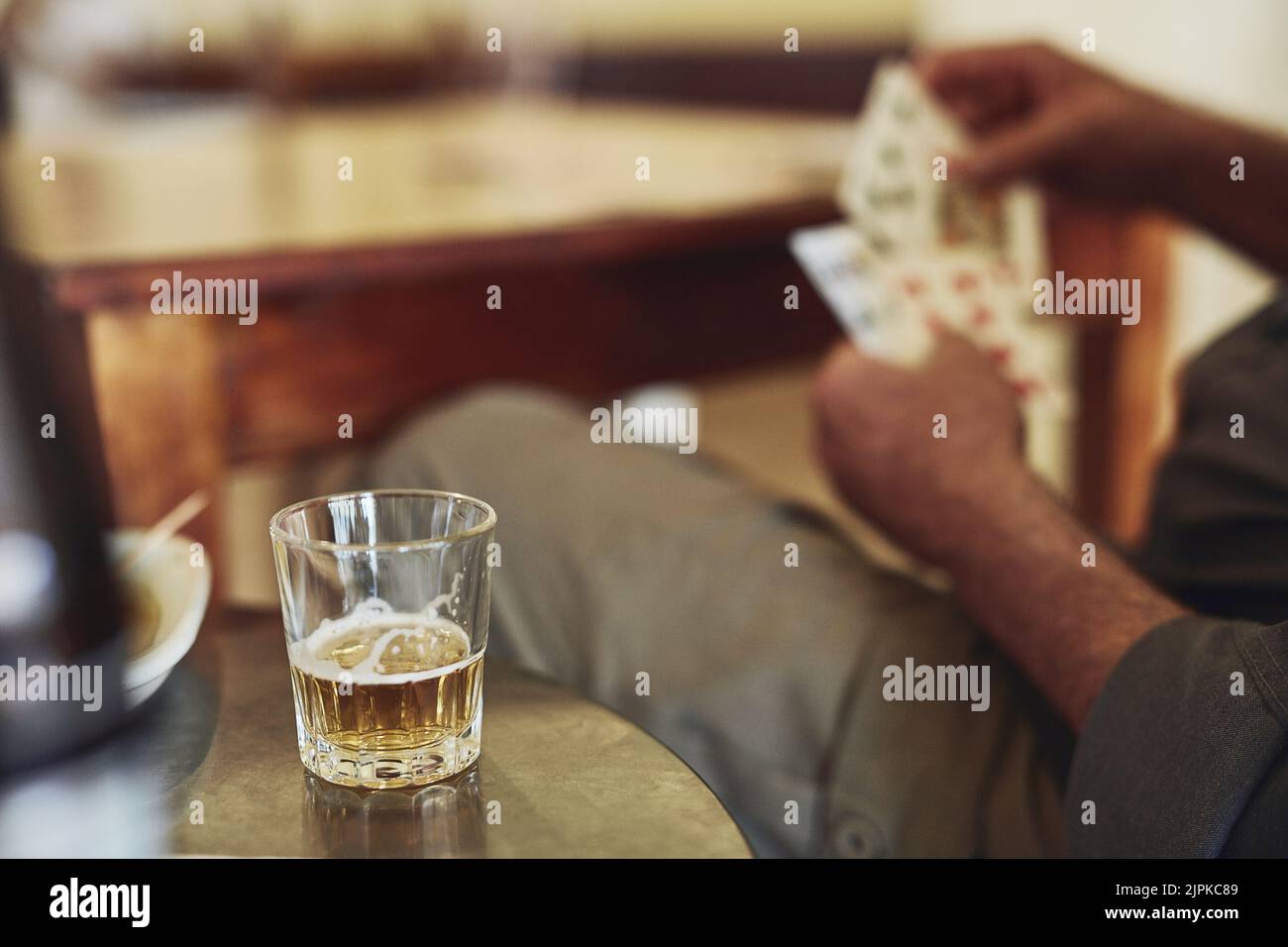 Einige Whisky und eine gute Hand. senioren spielen Poker in ihrem Altersheim. Stockfoto