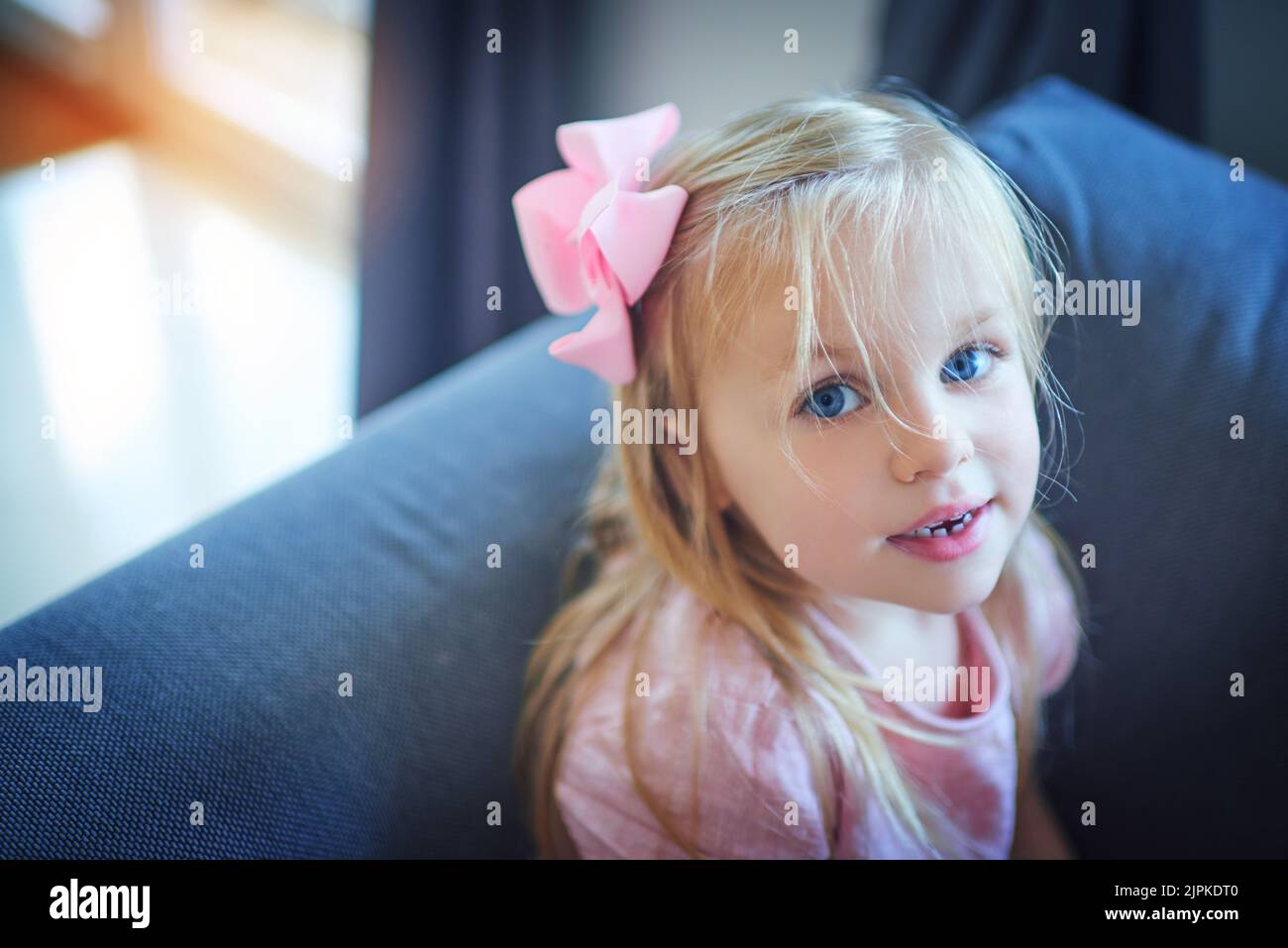 Zu niedlich für Worte. Hochwinkelporträt eines entzückenden kleinen Mädchens, das zu Hause auf dem Sofa sitzt. Stockfoto