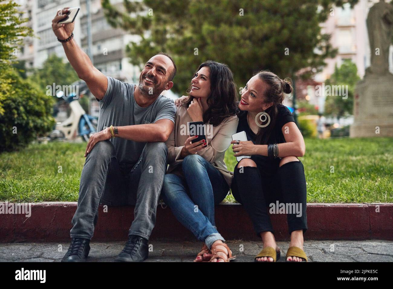 Ich muss meine Social-Media-Konten füttern. Drei Freunde, die ein Selfie machen, während sie sich in der Stadt amüsieren. Stockfoto