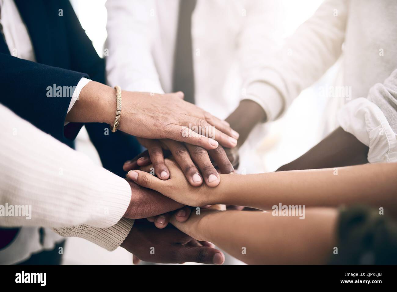 Wir stecken zusammen. Eine motivierte Gruppe von nicht erkennbaren Geschäftsleuten Hände bilden eine Huddle. Stockfoto