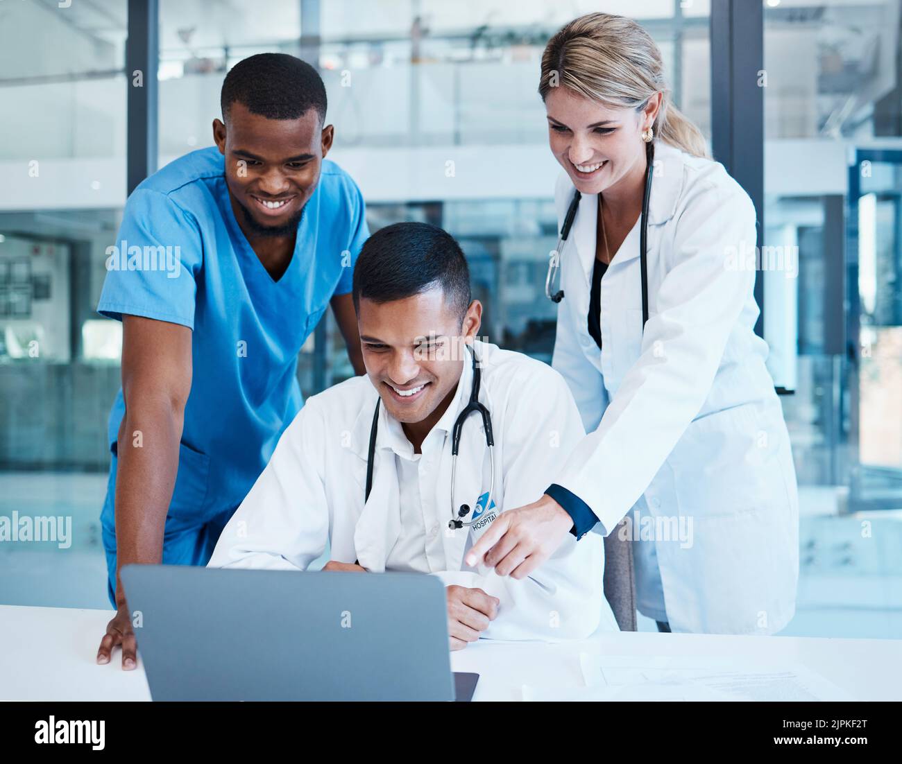 Ärzte, medizinische Fachkräfte oder Mitarbeiter im Gesundheitswesen mit Laptop sprechen, treffen oder planen medizinische Behandlung. Vielfältige Gruppe von glücklichen Klinik Stockfoto