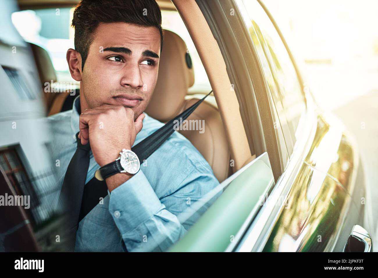 Ich hoffe, dieser Verkehr macht mich nicht zu spät für die Arbeit. Ein junger Geschäftsmann suchen besorgt, während der Fahrt mit dem Auto. Stockfoto