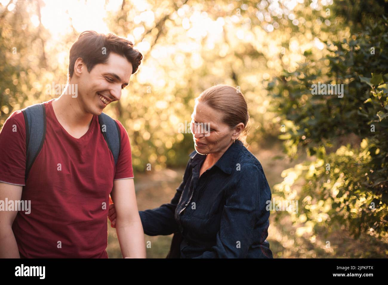 Glückliche Mutter und Sohn lachen, während sie im Sommer im Park stehen Stockfoto