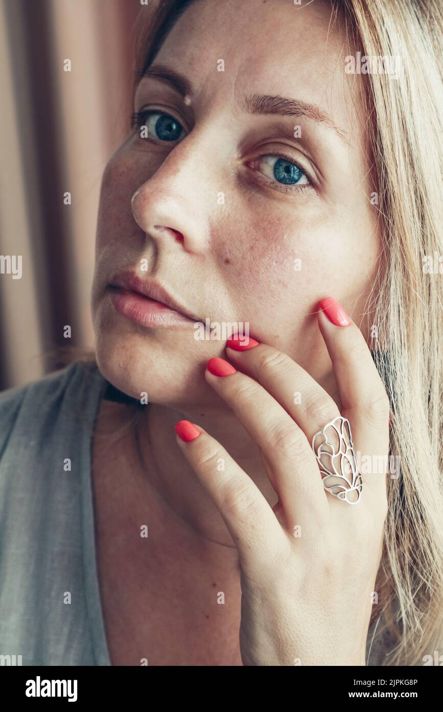 Schöne Frau mittleren Alters zeigt rote Schellack Maniküre auf Nägeln. Stockfoto