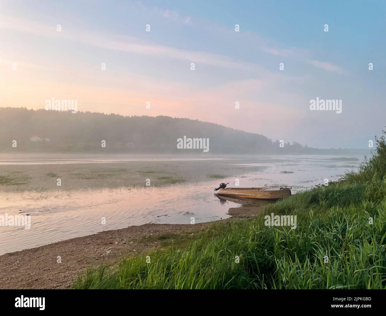 Rosa Sonnenaufgang und Boot auf dem Fluss Stockfoto