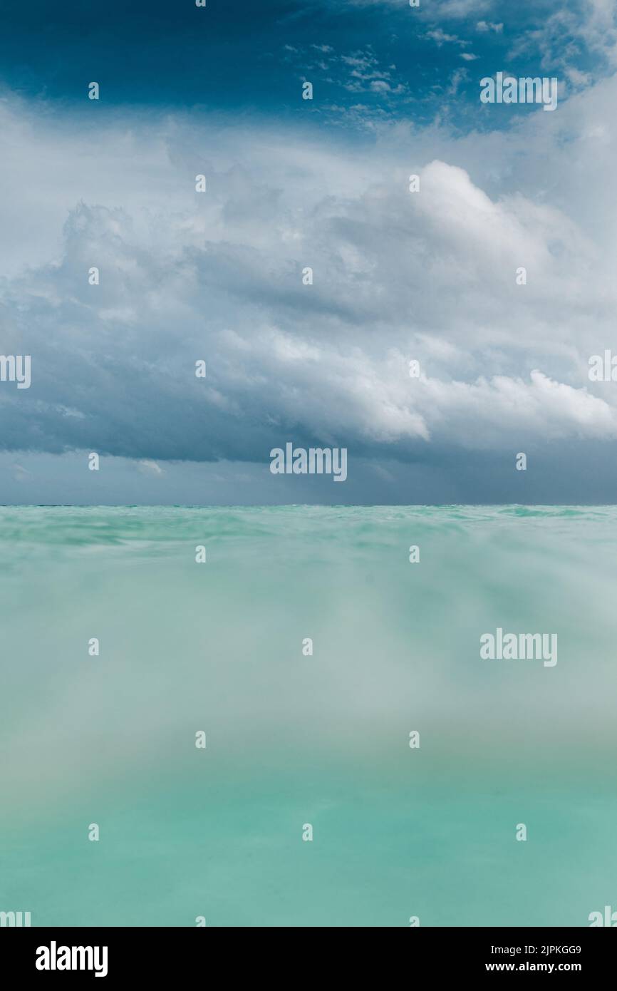 Stürmen Sie Wolken an einem kristallklaren Strand auf den Malediven Stockfoto