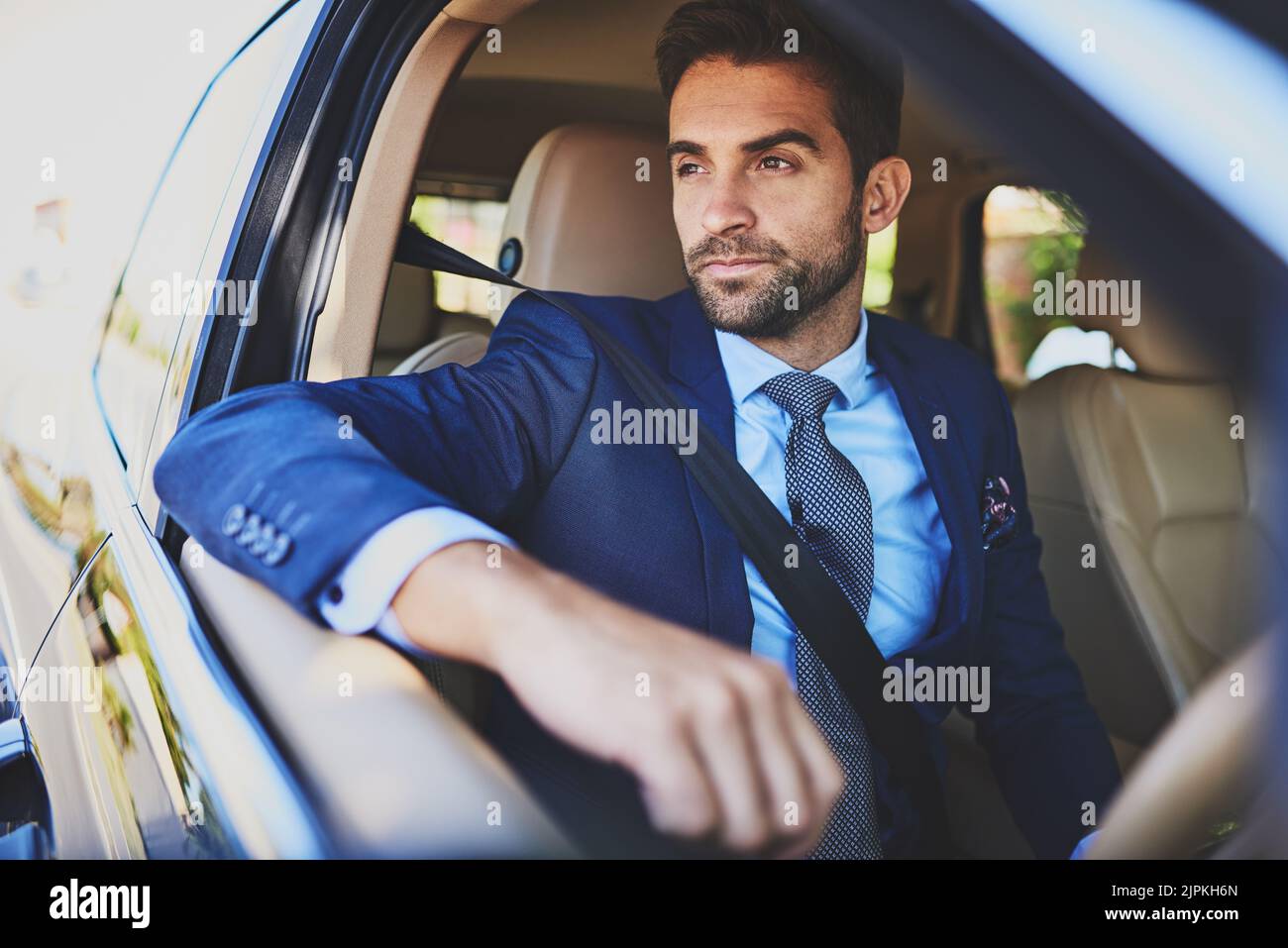 Dieser Verkehr ist immer verrückt. Ein selbstbewusster junger Geschäftsmann erwägt, während er in seinem Auto sitzt. Stockfoto